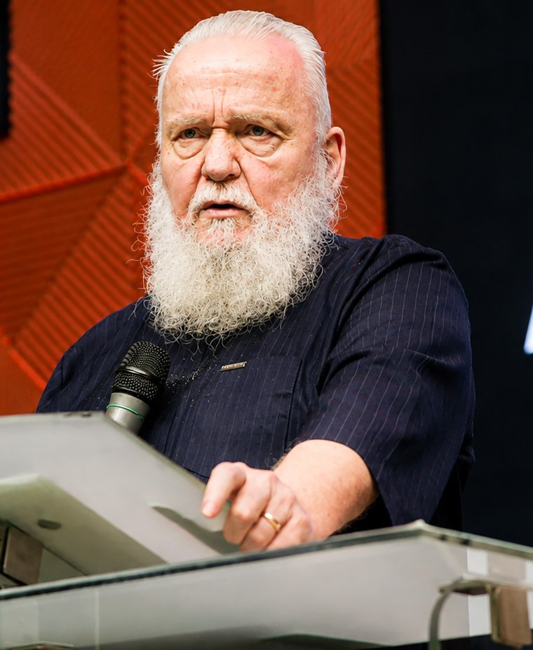 Rev. Prof. Gary S. Maxey preaching, pointing to emphasize a point