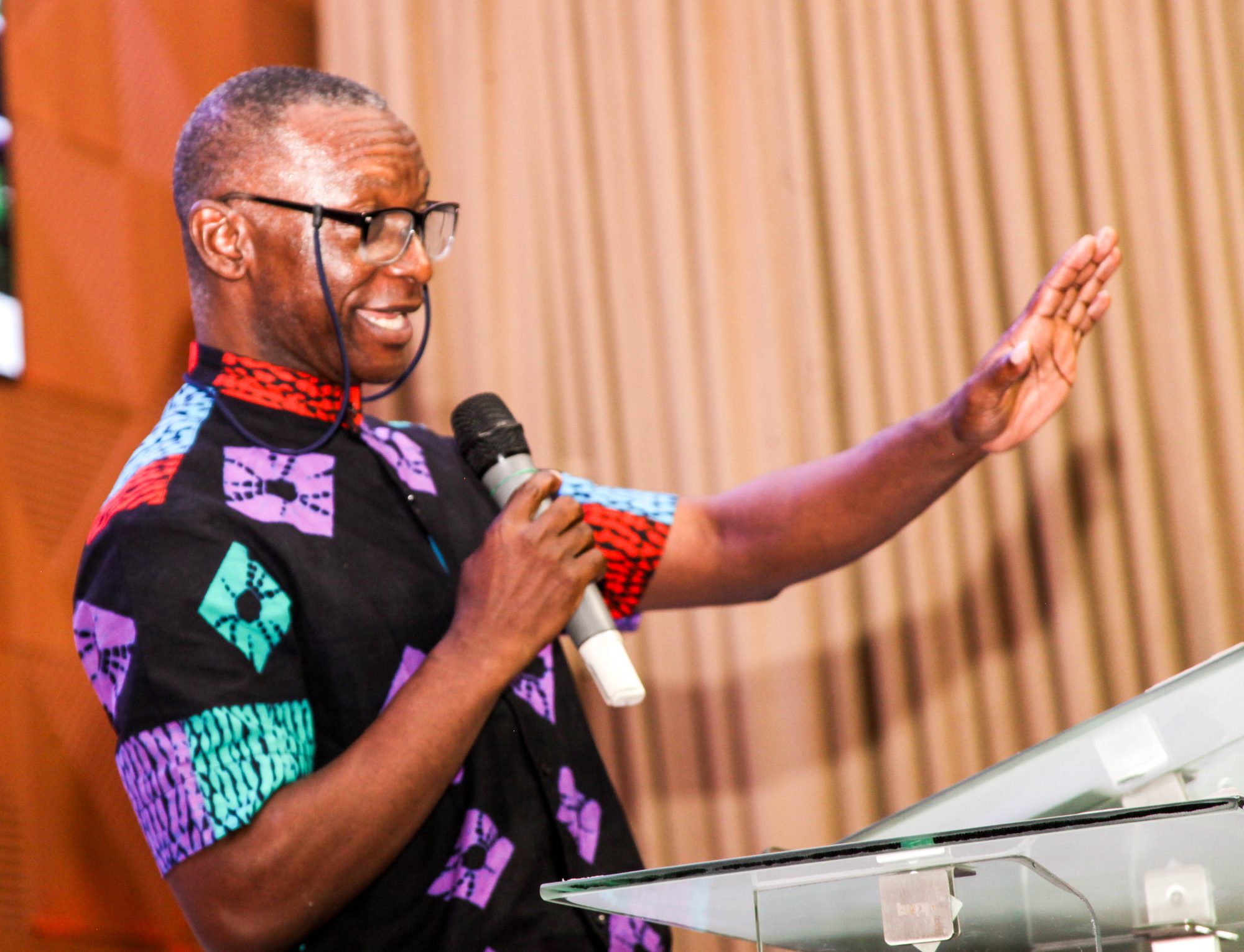 A minister preaching with joyful, animated expression at a Gary S. Maxey Network gathering